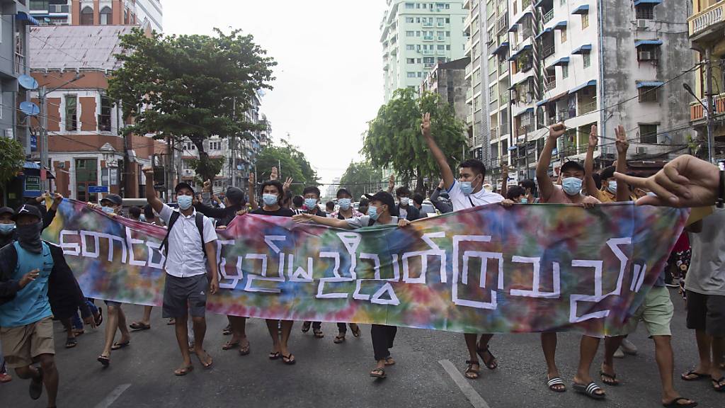 Anti-Putsch-Demonstranten mit der Aufschrift «Berge und Festland sind vereint» in Yangon. Foto: AP/dpa