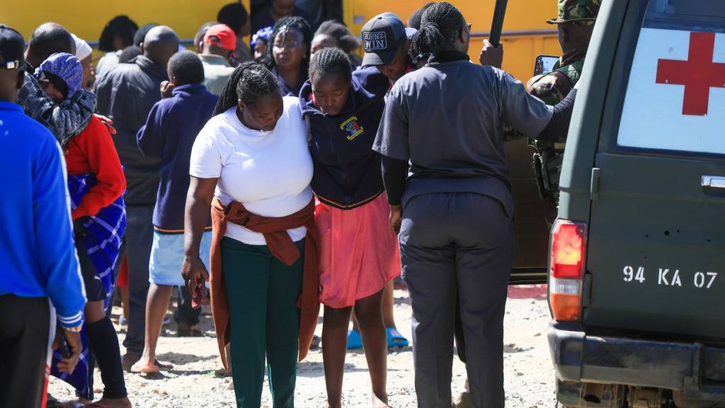 Eine verletzte Schülerin wird nach einem Brandausbruch am frühen Morgen an der Utumishi Girls School im Bezirk Gilgil in Zentralkenia evakuiert. Foto: Andrew Kasuku/AP/dpa
