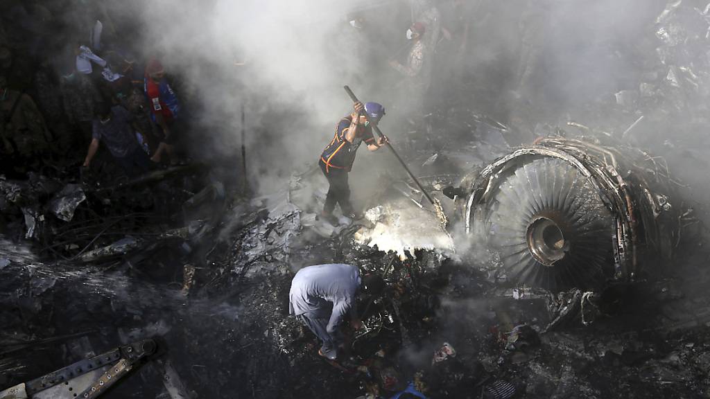 ARCHIV - Freiwillige Helfer und Einsatzkräfte suchen nach dem Absturz einer Maschine der Fluggesellschaft Pakistan International Airlines nach Überlebenden. Foto: Fareed Khan/AP/dpa
