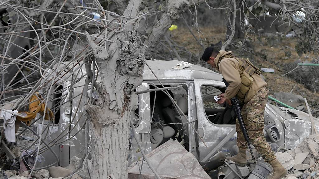 dpatopbilder - Ein Soldat der libanesischen Armee überprüft ein zerstörtes Auto im Dorf Aito im Nordlibanon. Foto: Hussein Malla/AP