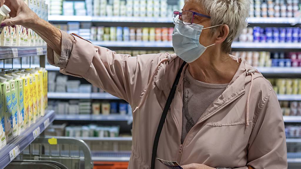 Die Kunden müssen zwar vielerorts eine Maske tragen, doch sie gehen in die Geschäfte zurück: eine Frau in der Migros in Basel (Bild vom 24. August).