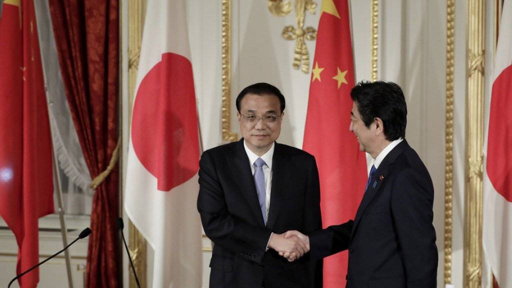 Handschlag als Symbol für das Tauwetter zwischen Peking und Tokio: Der japanische Premierminister Shinzo Abe (r) und sein chinesischer Amtskollege Li Keqiang (l) an einer gemeinsamen Medienkonferenz in Tokio.
