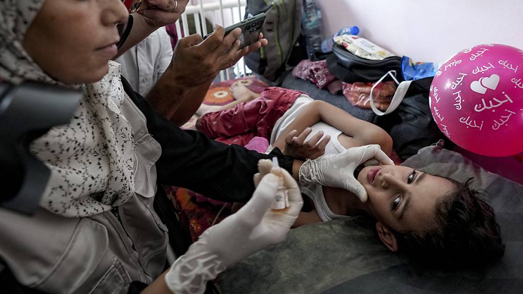 Ein Mitarbeiter des Gesundheitswesens verabreicht einem Kind in einem Krankenhaus in Chan Yunis eine Polio-Impfung. Foto: Abdel Kareem Hana/AP/dpa