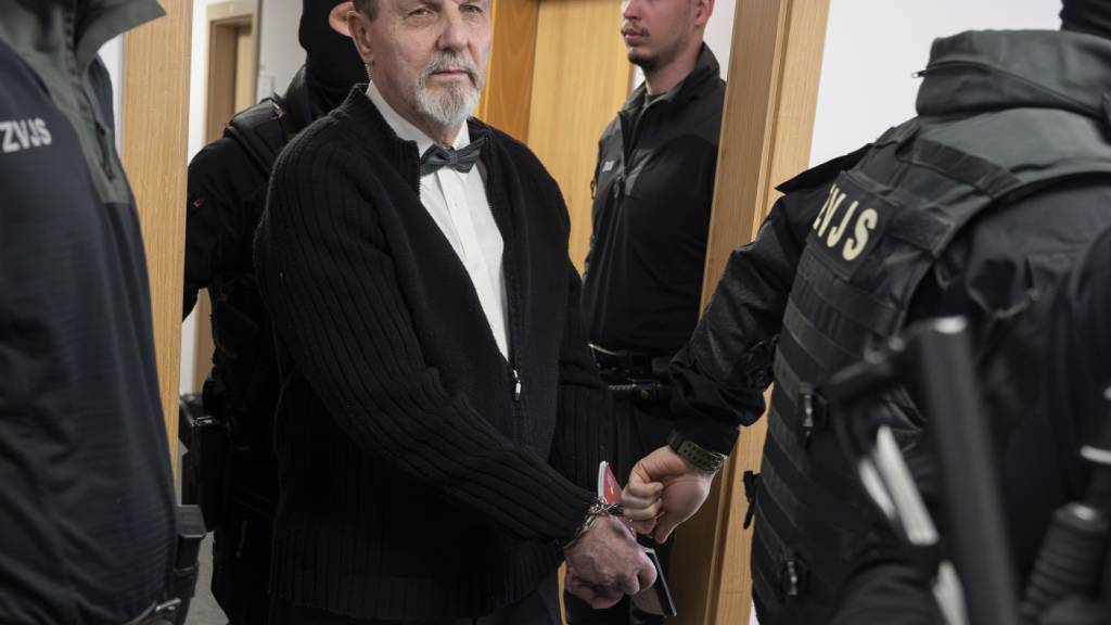dpatopbilder - Der im Fall des Attentats auf den slowakischen Ministerpräsidenten Robert Fico Angeklagte Juraj Cintula (M) wird mit Handschellen in den Gerichtssaal des Obersten Gerichts der Slowakei geführt. Foto: Martin Baumann/TASR/dpa