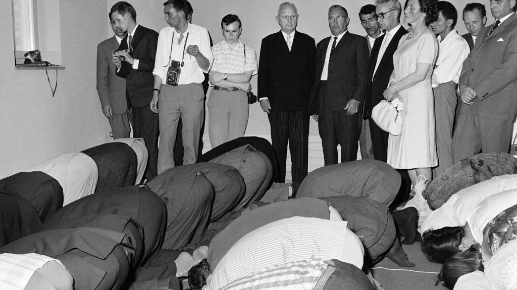 Etwas zugeknöpft sieht der damalige Zürcher FDP-Stadtpräsident Emil Landolt (im schwarzen Sakko) den Muslimen beim Beten zu. Anlass war die Eröffnung der Mahmud-Moschee im Jahr 1963. (Archivbild)