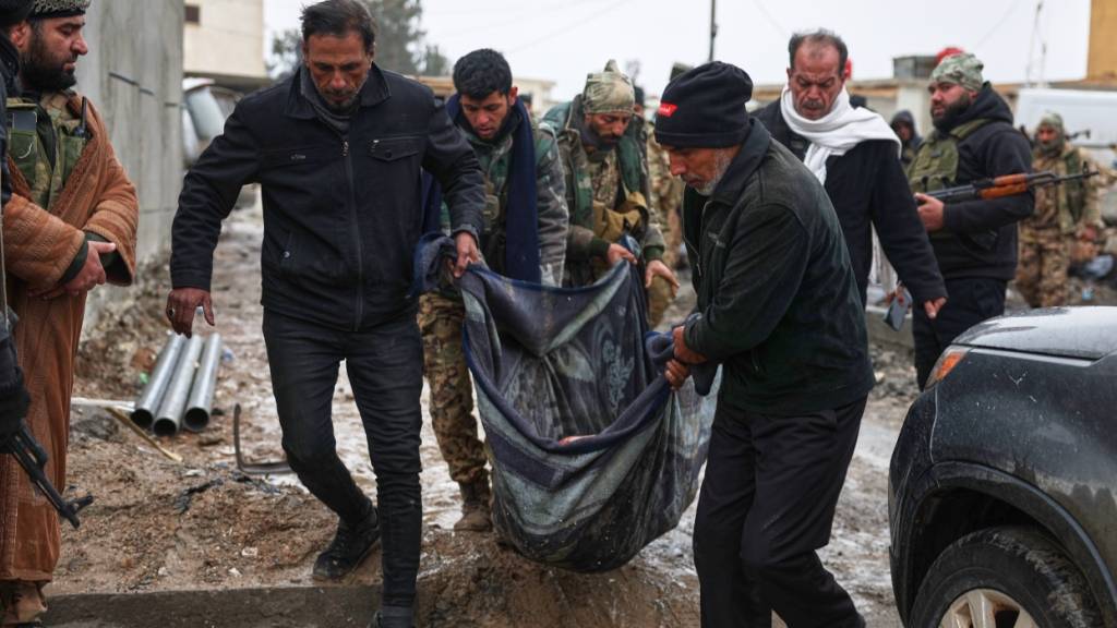 dpatopbilder - Syrische Regierungssoldaten und Einheimische tragen den Leichnam eines toten Zivilisten. Foto: Ghaith Alsayed/AP/dpa