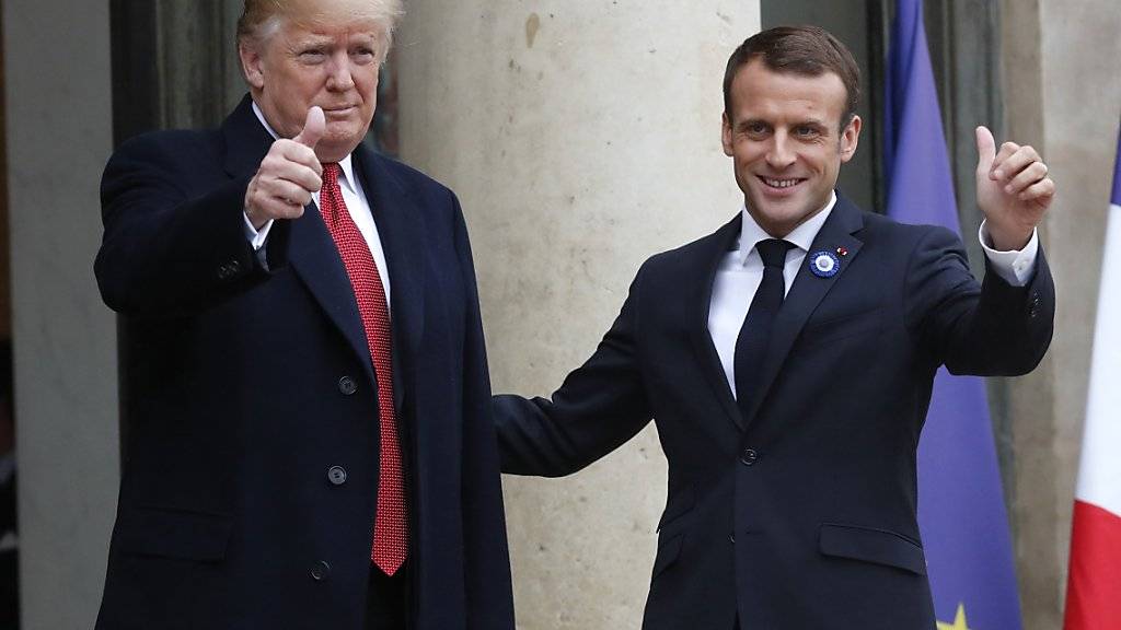 Lächeln vor den Kameras - nach bissigem Tweet: US-Präsident Trump (links) mit dem französischen Präsidenten Macron in Paris.
