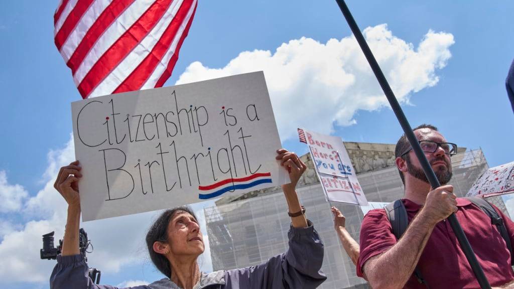 ARCHIV - Ein Demonstrant hält vor dem Supreme Court ein Schild mit der Aufschrift «Citizenship is a Birthright» (Archivbild). Foto: Jacquelyn Martin/AP/dpa