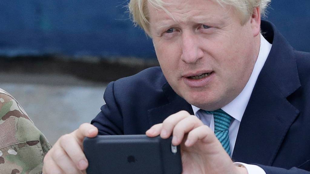 ARCHIV - Boris Johnson, damaliger Außenminister von Großbritannien, macht mit seiner Handykamera ein Bild bei einem Besuch in Nigeria. Der britische Ex-Premierminister Boris Johnson sorgt erneut für Schlagzeilen. Medienberichten zufolge soll der 59-Jährige angeblich den Pin-Code für sein altes Handy vergessen haben. Foto: Sunday Alamba/AP/dpa