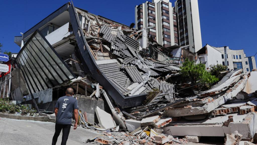 Ein Mann blickt auf ein eingestürztes Gebäude, nachdem ein Erdbeben die Stadt Manizales in Kolumbien erschüttert hatte. Foto: Dario Cardona/AP/dpa