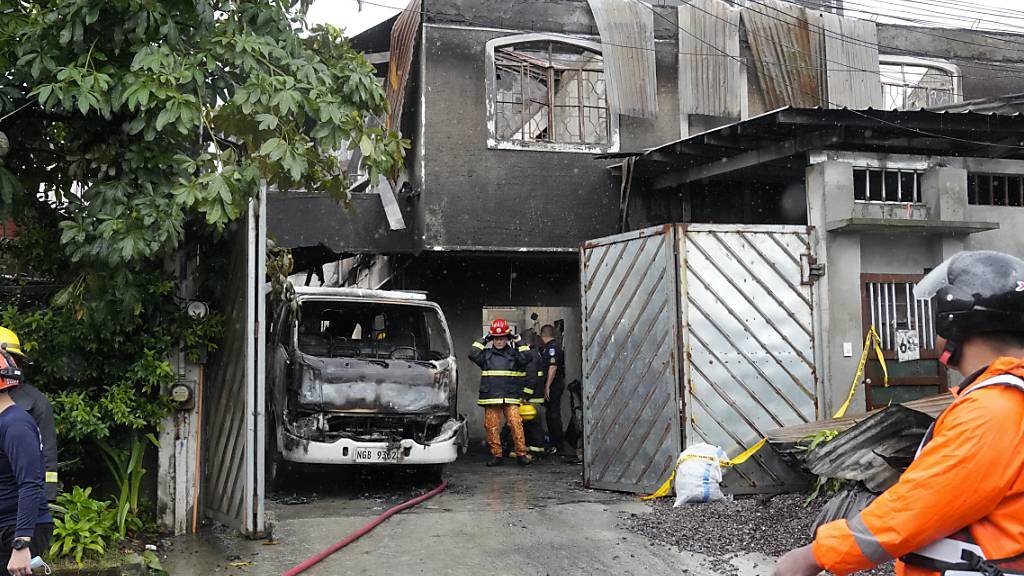 Feuerwehrleute agieren am Einsatzort. Bei einem Brand in einem zweistöckigen Haus auf den Philippinen sind mindestens 16 Menschen ums Leben gekommen. Foto: Aaron Favila/AP/dpa