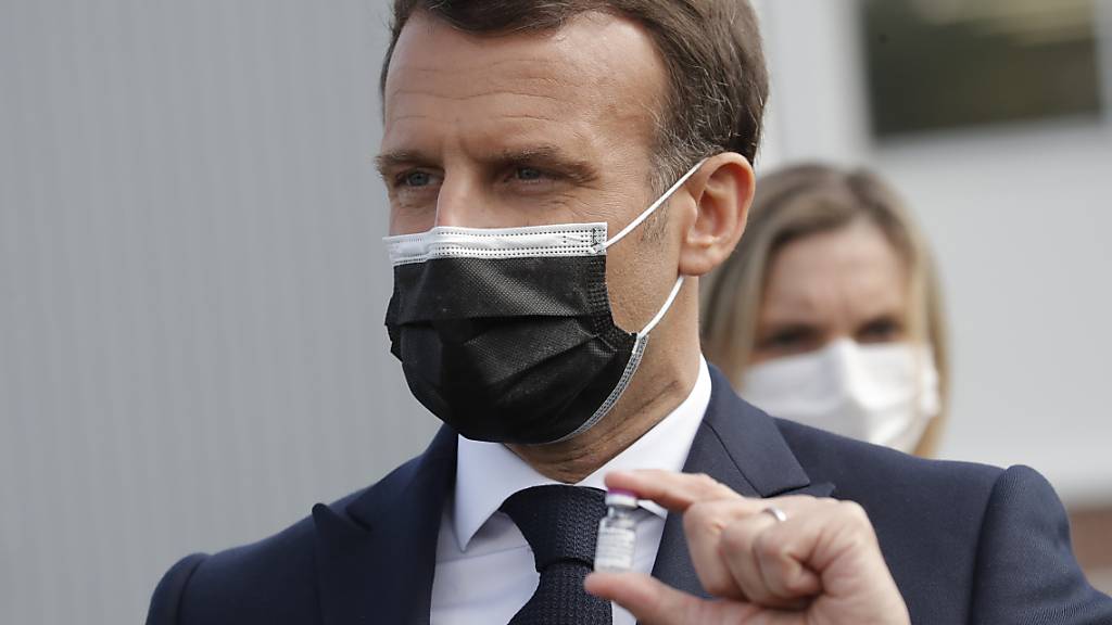 Der französische Präsident Emmanuel Macron hält eine Impfdosis nach einem Besuch in einer Fabrik der Firma Delpharm, die den Corona-Impfstoff von Pfizer/Biontech in Frankreich abfüllt.