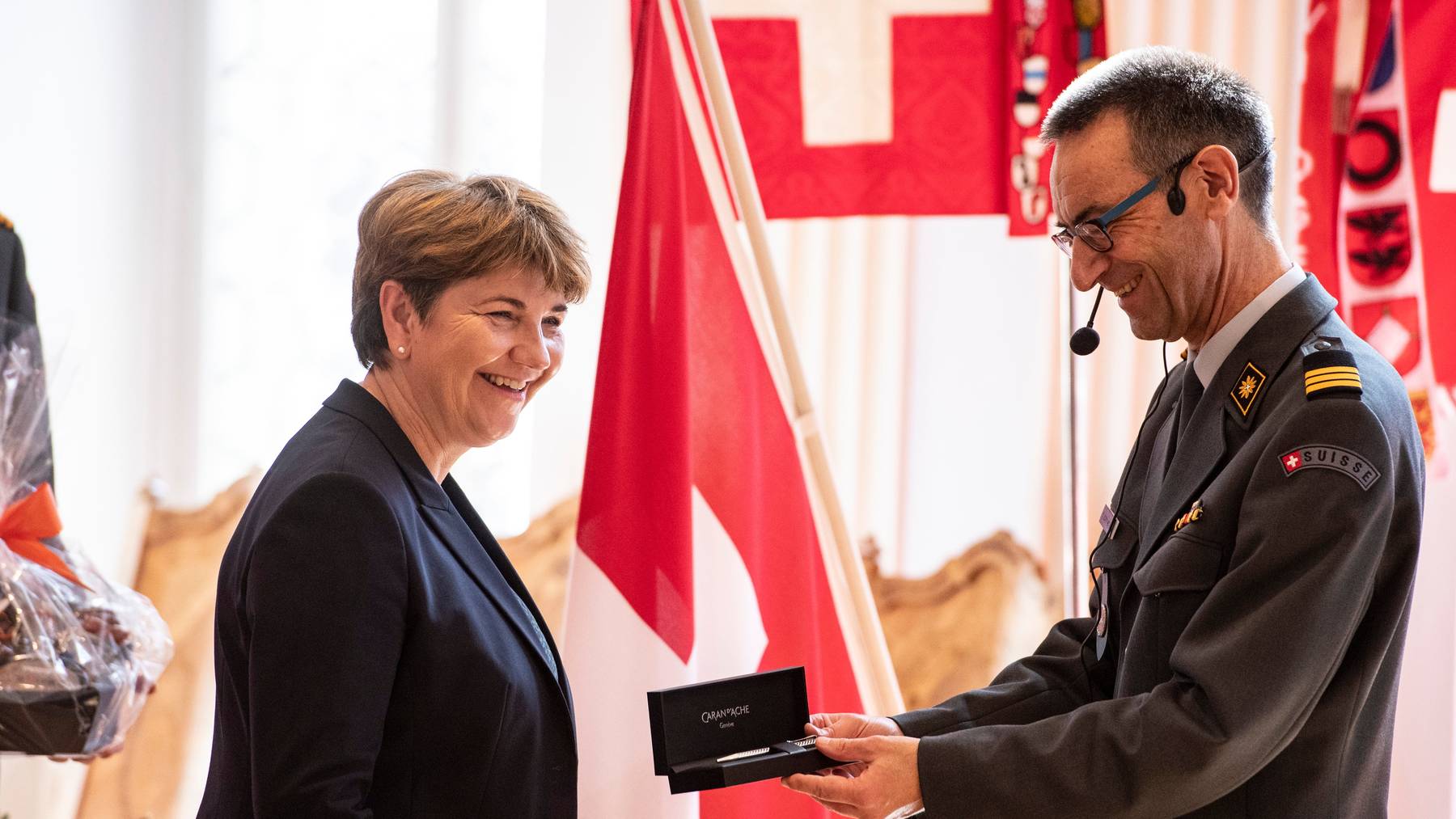 Stefan Holenstein, Präsident der Offiziersgesellschaft, schenkt Verteidigungsministerin Viola Amherd einen Kugelschreiber.