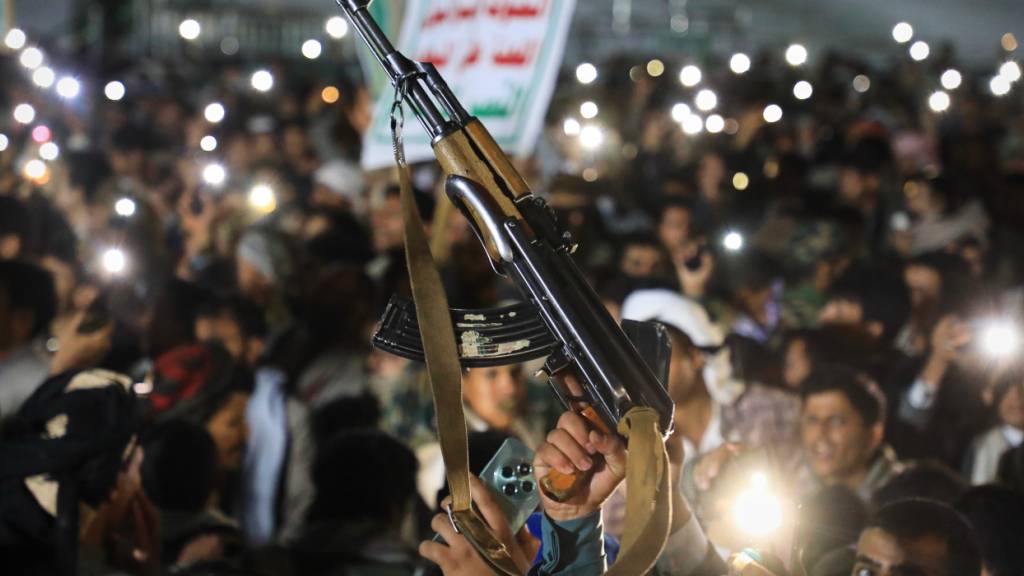 dpatopbilder - Ein Anhänger reckt ein AK-47-Gewehr in die Höhe während einer Kundgebung, die von den jemenitischen Huthi-Rebellen in der von den Huthis kontrollierten jemenitischen Hauptstadt organisiert wurde, um die Eroberung der Insel Mayun in der strategisch wichtigen Meerenge von Bab el-Mandeb zu feiern. Foto: Osamah Abdulrahman/AP/dpa