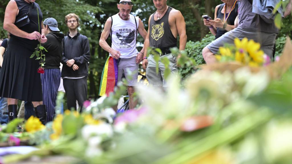 Menschen trauern in der Nähe des Tatorts. Am Rande des Christopher Street Day in Berlin war das Fahrzeug in eine Menschenmenge gefahren. Foto: Sebastian Gollnow/dpa - ACHTUNG: Nur zur redaktionellen Verwendung im Zusammenhang mit der aktuellen Berichterstattung und nur mit vollständiger Nennung des vorstehenden Credits