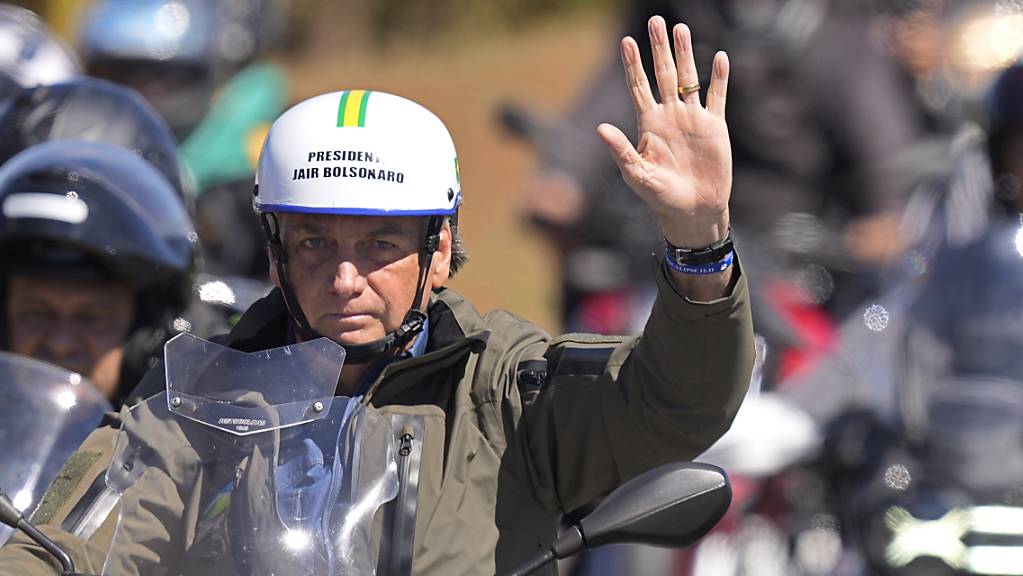 Jair Bolsoanro, Präsident von Brasilien, trägt während einer Motorrad-Rallye anlässlich des Vatertags in Brasilien, einen Helm mit seinen Initialen. Foto: Eraldo Peres/AP/dpa