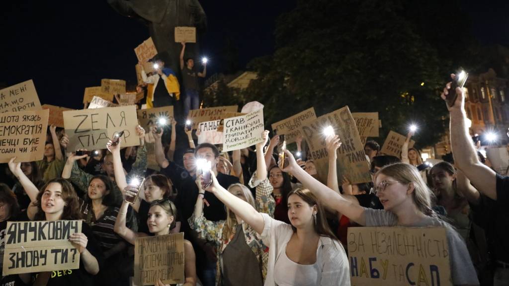 dpatopbilder - Teilnehmer halten Transparente während einer Demonstration gegen ein Gesetz, das die Unabhängigkeit von Antikorruptionsorganen beschränkt. Das neue Gesetz hat in der Ukraine zu den größten Protesten seit Kriegsbeginn geführt. Foto: Mykola Tys/AP/dpa