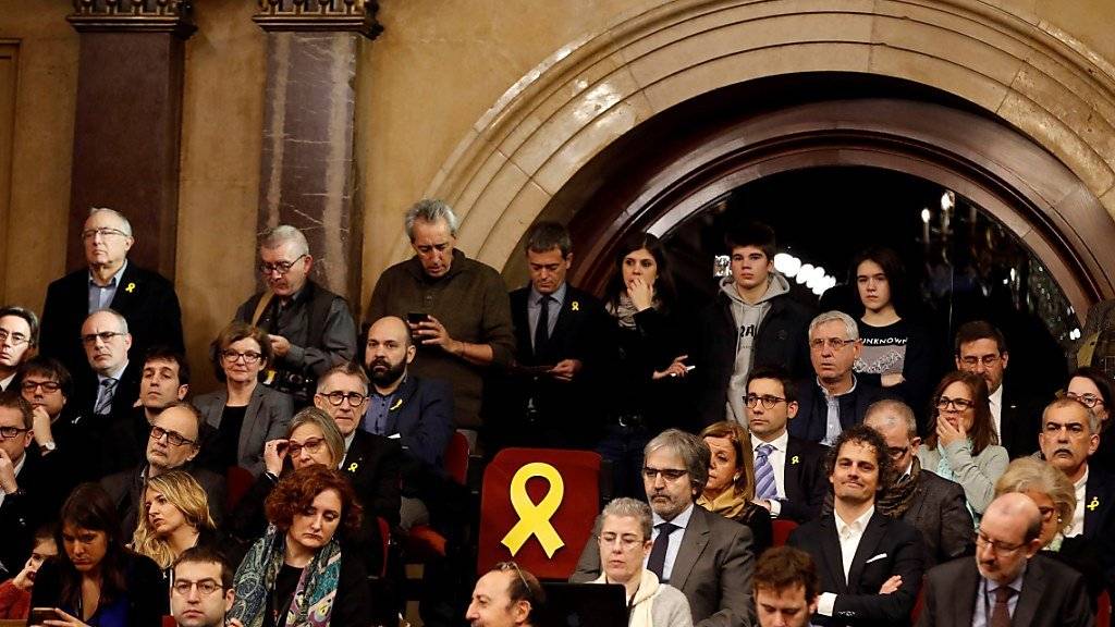 Das neue katalanische Parlament ist erstmals nach dessen Auflösung wieder zusammengetreten. Die Sitze der Separatisten, die in Haft sind und deshalb nicht an der Sitzung teilnehmen können, wurden mit gelben Schleifen dekoriert.