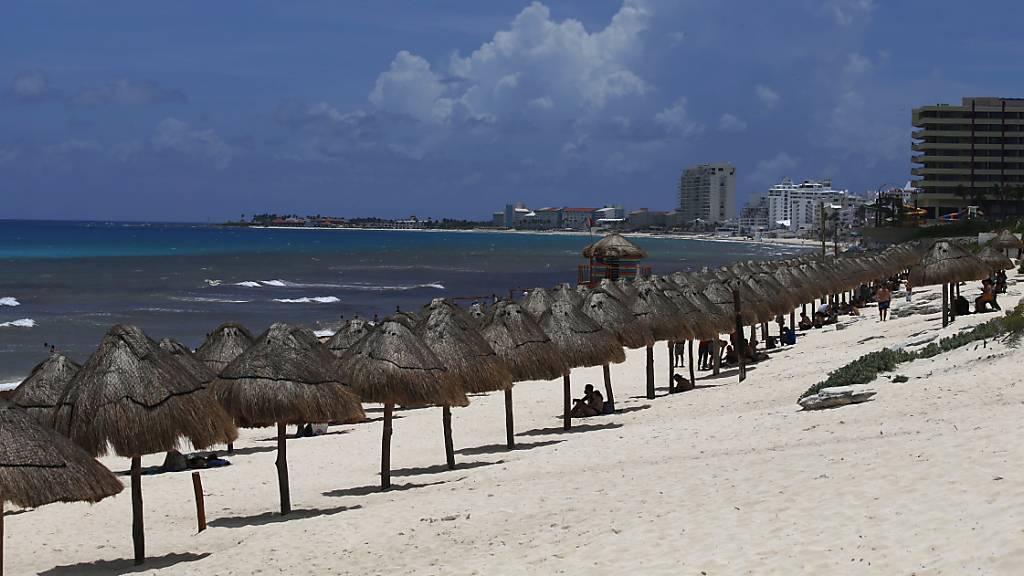 Touristen genießen den Strand vor der Ankunft des Hurrikans «Grace» in Cancun im mexikanischen Bundesstaat Quintana Roo. Wegen des herannahenden Hurrikans «Grace» sind im mexikanischen Touristenort Tulum die Hotels evakuiert worden. Die Gäste seien in Notunterkünften untergebracht worden. Foto: Marco Ugarte/AP/dpa