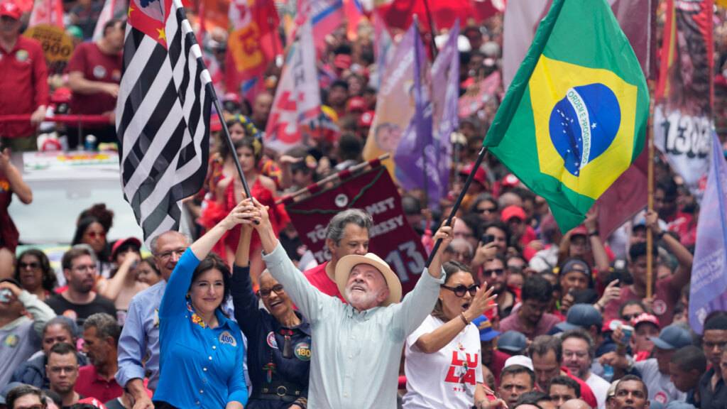 ARCHIV - Präsident Luiz Inácio Lula da Silva schwenkt bei einer Wahlkampfveranstaltung einen Tag vor den Parlamentswahlen in São Paulo die Flaggen Brasiliens und des Bundesstaates São Paulo. Foto: Andre Penner/AP/dpa