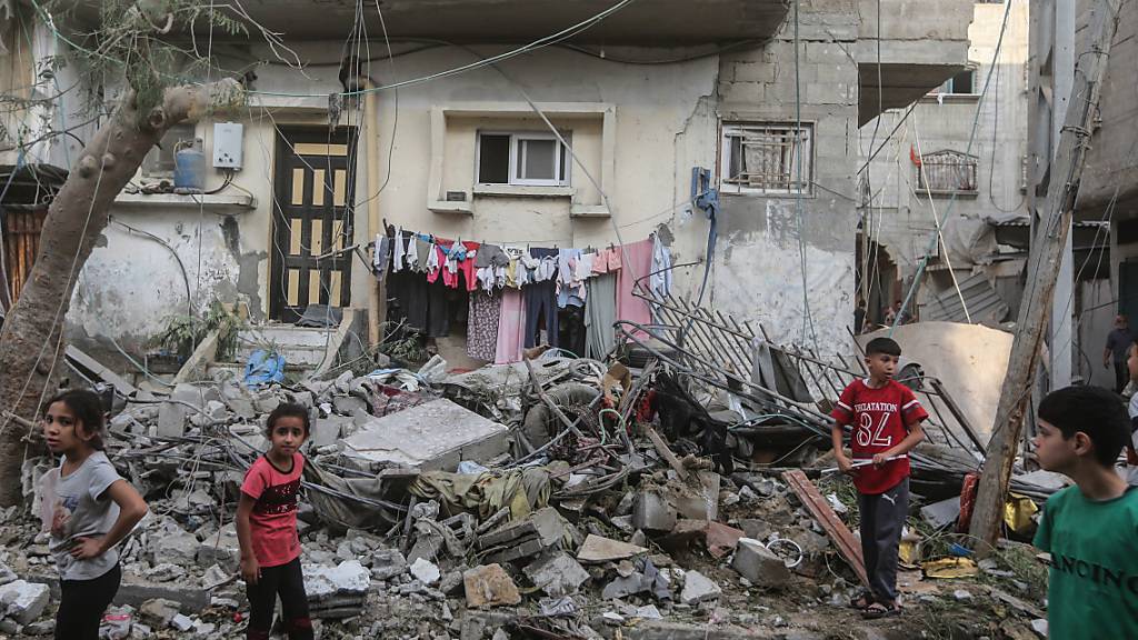 Junge Palästinenser laufen durch die Trümmer von Gebäuden, die bei israelischen Luftangriffen zerstört wurden. Foto: Mohammed Talatene/dpa