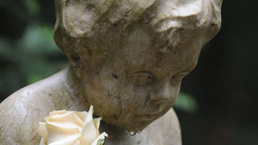Ein Engel mit Rose auf einem Friedhof in München. Im Kanton Bern sollen künftig alle fehlgeborenen Kinder bestattet werden können. (Symbolbild)
