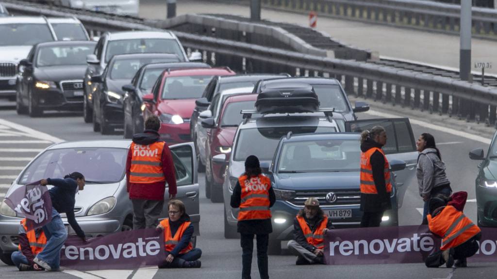 Aktivisten von Renovate Switzerland protestieren am 7. April 2023 vor dem Gotthardtunnel bei Göschenen im Kanton Uri während des Oster-Reiseverkehrs. (Archivbild)