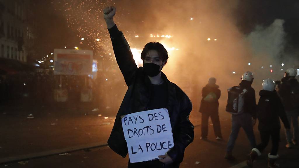 Ein Teilnehmer hält während eines Protests gegen das neue Sicherheitsgesetz ein Schild mit der Aufschrift «Land der Polizeirechte» in der Hand. Foto: Francois Mori/AP/dpa