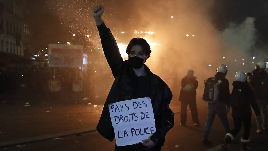 Ein Teilnehmer hält während eines Protests gegen das neue Sicherheitsgesetz ein Schild mit der Aufschrift «Land der Polizeirechte» in der Hand. Foto: Francois Mori/AP/dpa