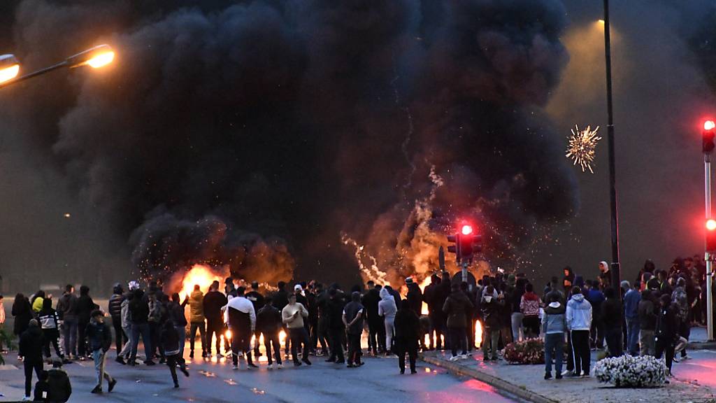 Demonstranten stehen auf einer Straße vor brennenden Reifen. Nachdem rechtsextreme Aktivisten in Malmö einen Koran verbrannten, kam es zu massiven Protesten und Unruhen. Foto: Uncredited/TT NEWS AGENCY/AP/dpa