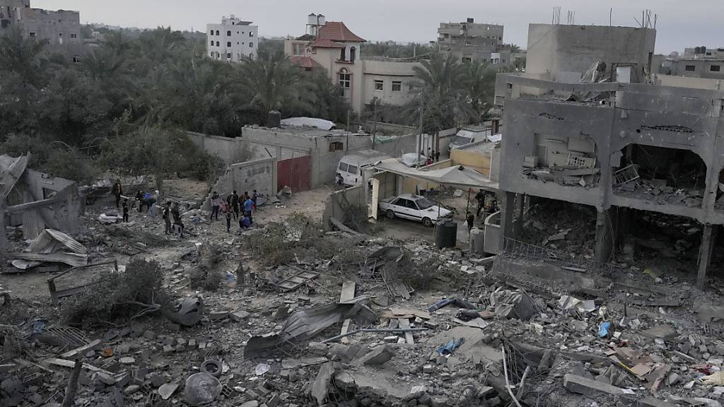 Palästinenser betrachten die Trümmer eines Gebäudes im Gazastreifen, das bei einer israelischen Bombardierung zerstört wurde. Foto: Hatem Moussa/AP/dpa