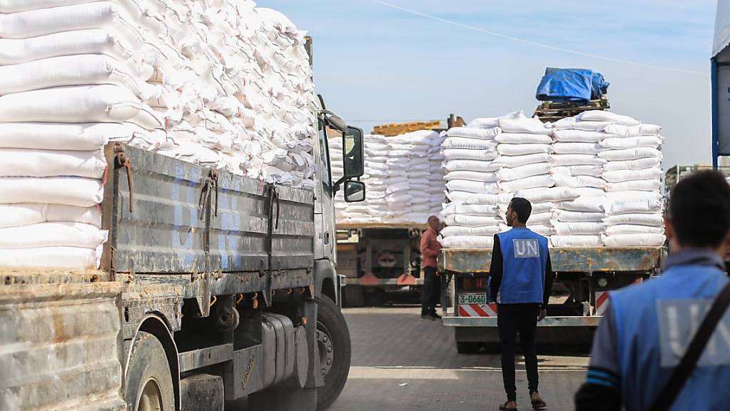 Zwei Mitarbeiter laden Mehlsäcke auf einen Lastwagen im Verteilungszentrum des Hilfswerks.