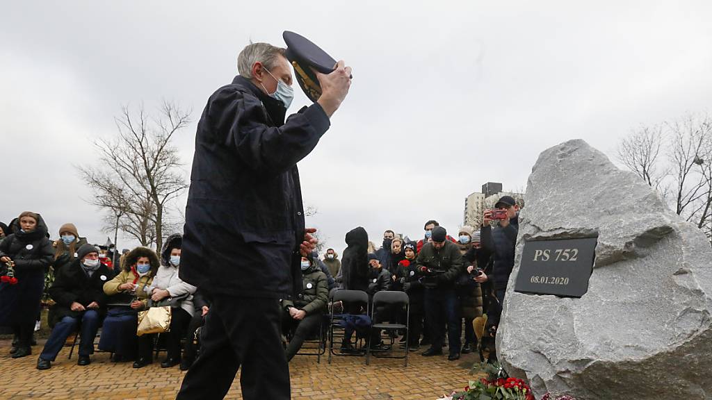 Ein Pilot legt Blumen vor der Gedenkstätte für die Opfer des Absturzes einer ukrainischen Passagiermaschine nieder. Ein Jahr nach dem Abschuss des Flugzeuges dringt Präsident Selenskyj auf den Beginn eines Gerichtsverfahrens.