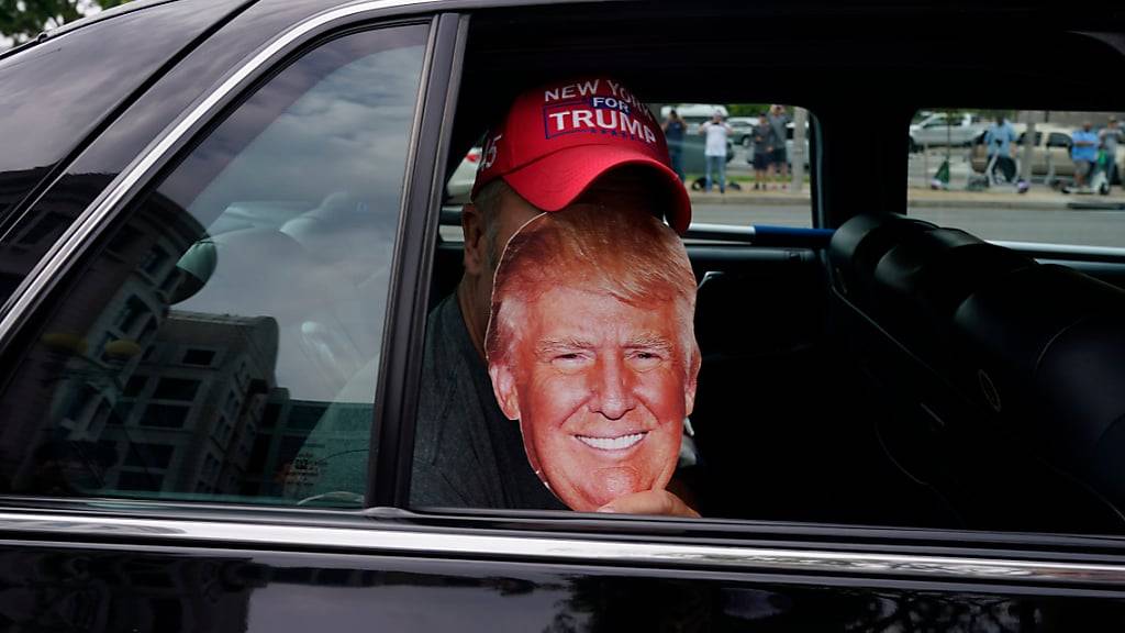 Eine Person in einem Auto hält ein Bild des ehemaligen US-Präsidenten Trump in der Nähe des E. Barrett Prettyman U.S. Federal Courthouse. Foto: Jacquelyn Martin/AP/dpa