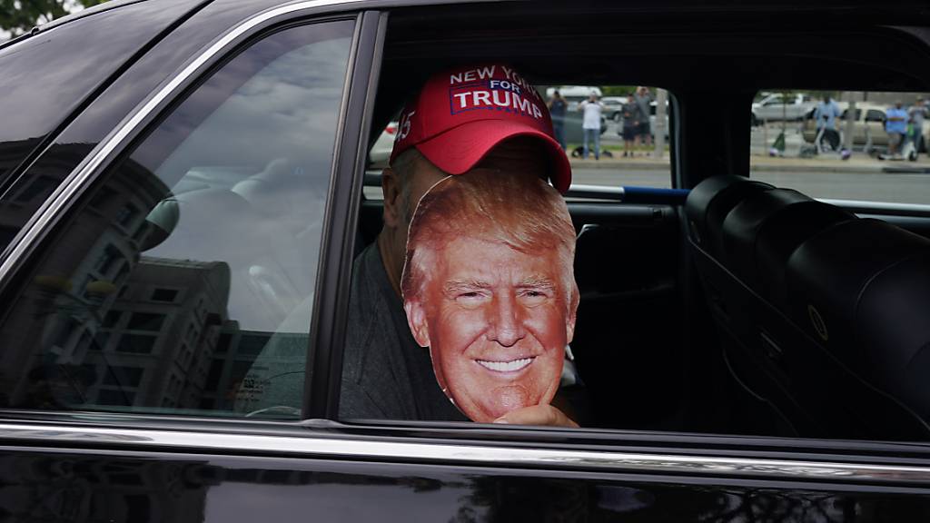 Eine Person in einem Auto hält ein Bild des ehemaligen US-Präsidenten Trump in der Nähe des E. Barrett Prettyman U.S. Federal Courthouse. Foto: Jacquelyn Martin/AP/dpa