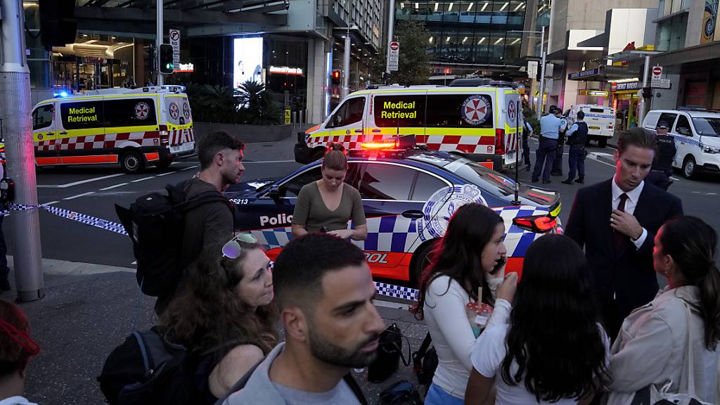 dpatopbilder - Eine Menschenmenge versammelt sich vor dem Westfield Shopping Centre. Medienberichten zufolge wurden in dem Einkaufszentrum in Sydney mehrere Menschen niedergestochen und eine Person von der Polizei erschossen. Foto: Rick Rycroft/AP