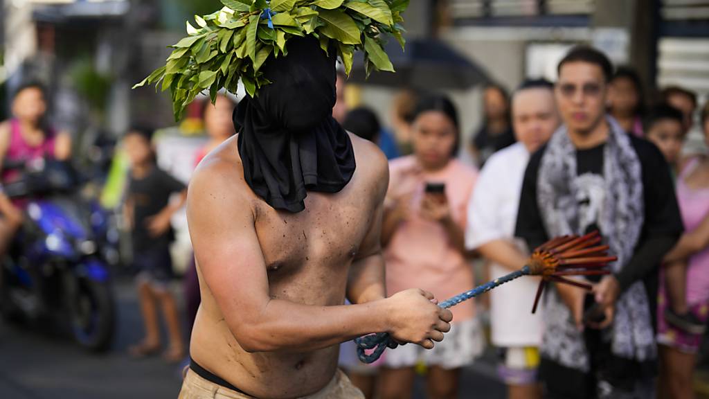 Ein vermummter philippinischer Büßer geißelt sich in Manila. Foto: Aaron Favila/AP