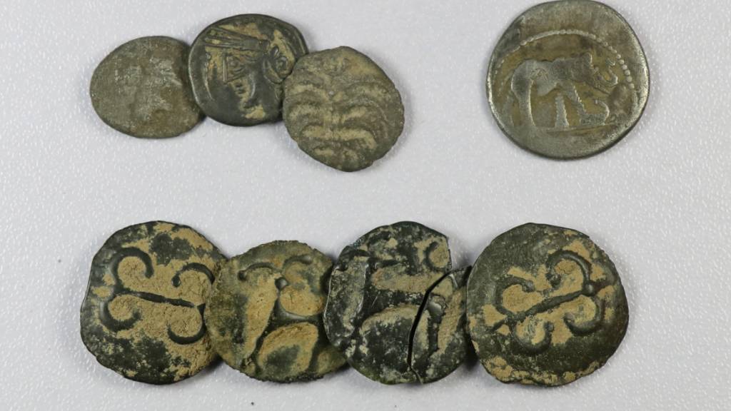 Sieben keltische Münzen und ein römisch-republikanischer Silberdenar in unrestauriertem Zustand nach der Auffindung im Kiesabbaugebiet Cham-Oberwil.