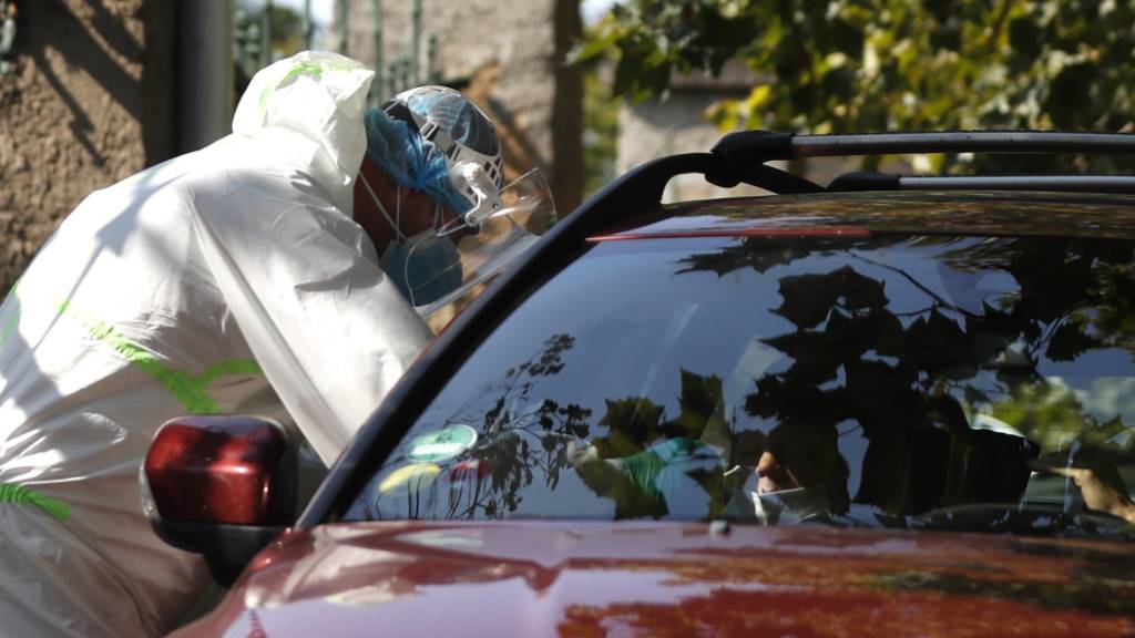 Prag: Ein junger Autofahrer wird an einer Drive-in-Teststation auf Covid-19-Symptome geprüft. In Tschechien breitet sich das Coronavirus weiter rasant aus. Foto: Petr David Josek/AP/dpa