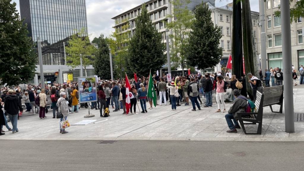 Mit Kantons- und Schweizerfahnen: Die Massnahmen-Gegnerinnen und -Gegner bei der Besammlung auf dem Kornhausplatz in St. Gallen.