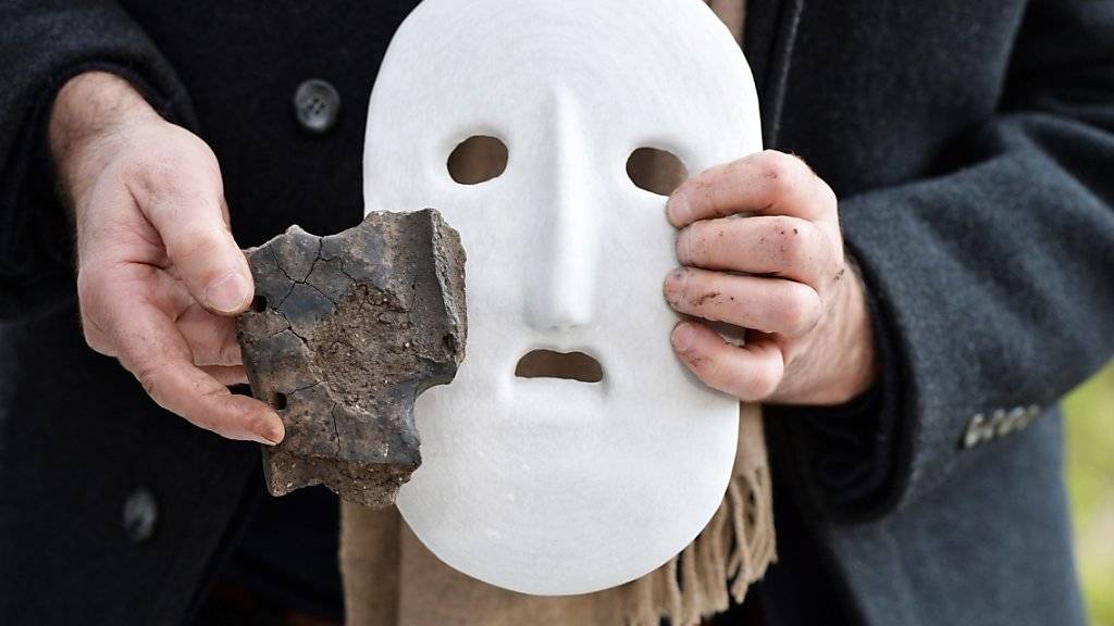 Eine Scherbe der steinzeitlichen Totenmaske und ein Modell, wie sie ausgesehen haben könnte.