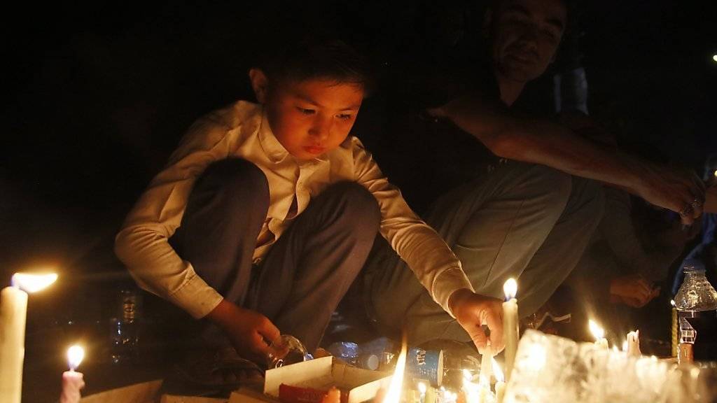 Trauer in Kabul: Ein afghanischer Bub zündet eine Kerze an in Gedenken an die mindestens 80 Todesopfer, die bei einem Selbstmordanschlag auf eine Demonstration in Kabul starben.