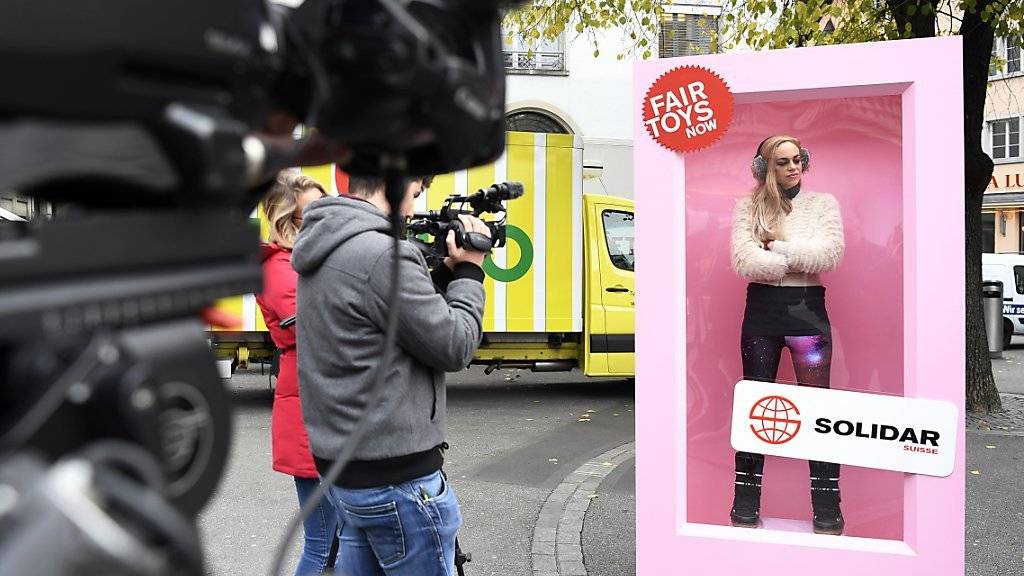 Eine Videojournalistin filmt die «Protest-Barbie» beim Zürcher Paradeplatz. Mit der Barbie will Solidar Suisse Aufmerksamkeit erregen für die unwürdigen Arbeitsbedingungen, unter denen Spielzeuge wie Barbiepuppen in China produziert werden.