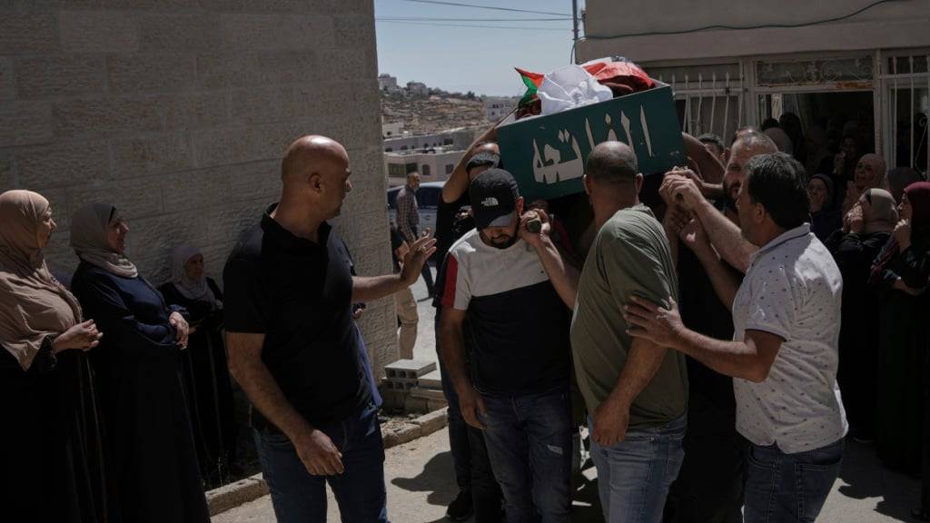 Trauernde tragen einen Leichnam. Nach Angaben der palästinensischen Gesundheitsbehörden starb der Mann, nachdem er von Siedlern erschossen wurde. Foto: Mahmoud Illean/AP/dpa