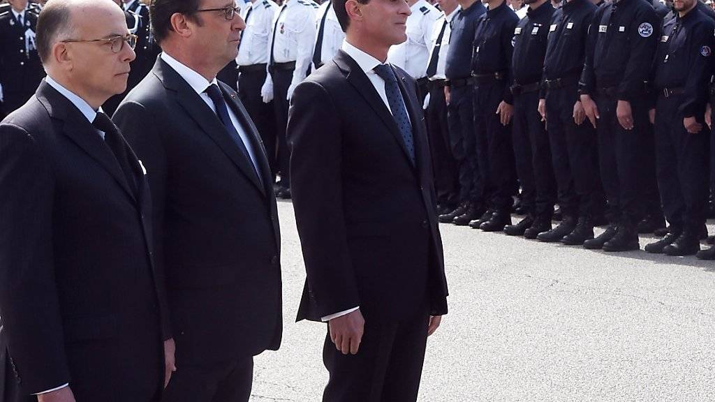 Staatspräsident Hollande (Mitte), Innenminister Bernard Cazeneuve (l) und Premierminister Manuel Valls bei der Trauerfeier in Versailles.