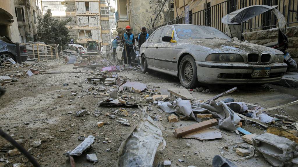 dpatopbilder - Arbeiter räumen Trümmer von einer Straße in Beirut, nachdem ein Wohnhaus von einem israelischen Luftangriff getroffen wurde. Foto: Marwan Naamani/dpa