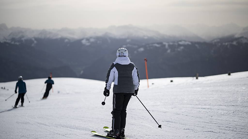 Skifahrer am 7. April 2024, dem letzten Tag der Saison, auf der Piste am Pizol, während Saharastaub die Luft eintrübt.