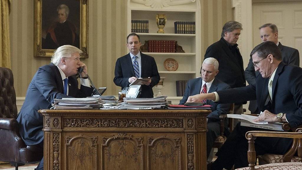 US-Präsident Donald Trump (l) im Telefongespräch mit Russlands Präsident Wladimir Putin. Mit im Oval Office unter anderem Vize-Präsident Mike Pence (Mitte sitzend) und Sicherheitsberater Michael Flynn (r)