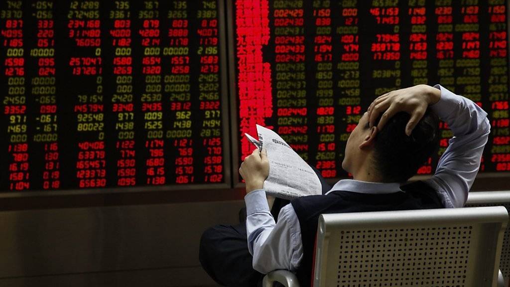 Ein Investor in Peking schaut sich am Donnerstag die Aktienkurse an. Die chinesische Notenbank will die Wirtschaft nun mit einer weiteren Leitzinssenkung ankurbeln.