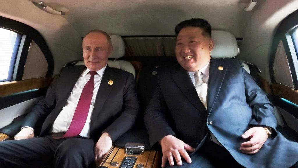 HANDOUT - Kim Jong Un, Machthaber in Nordkorea, und Wladimir Putin in einem Fahrzeug im Rahmen einer Militärparade. Foto: Uncredited/KCNA/KNS/dpa